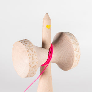 Yellow heart on the spike of a kendama.